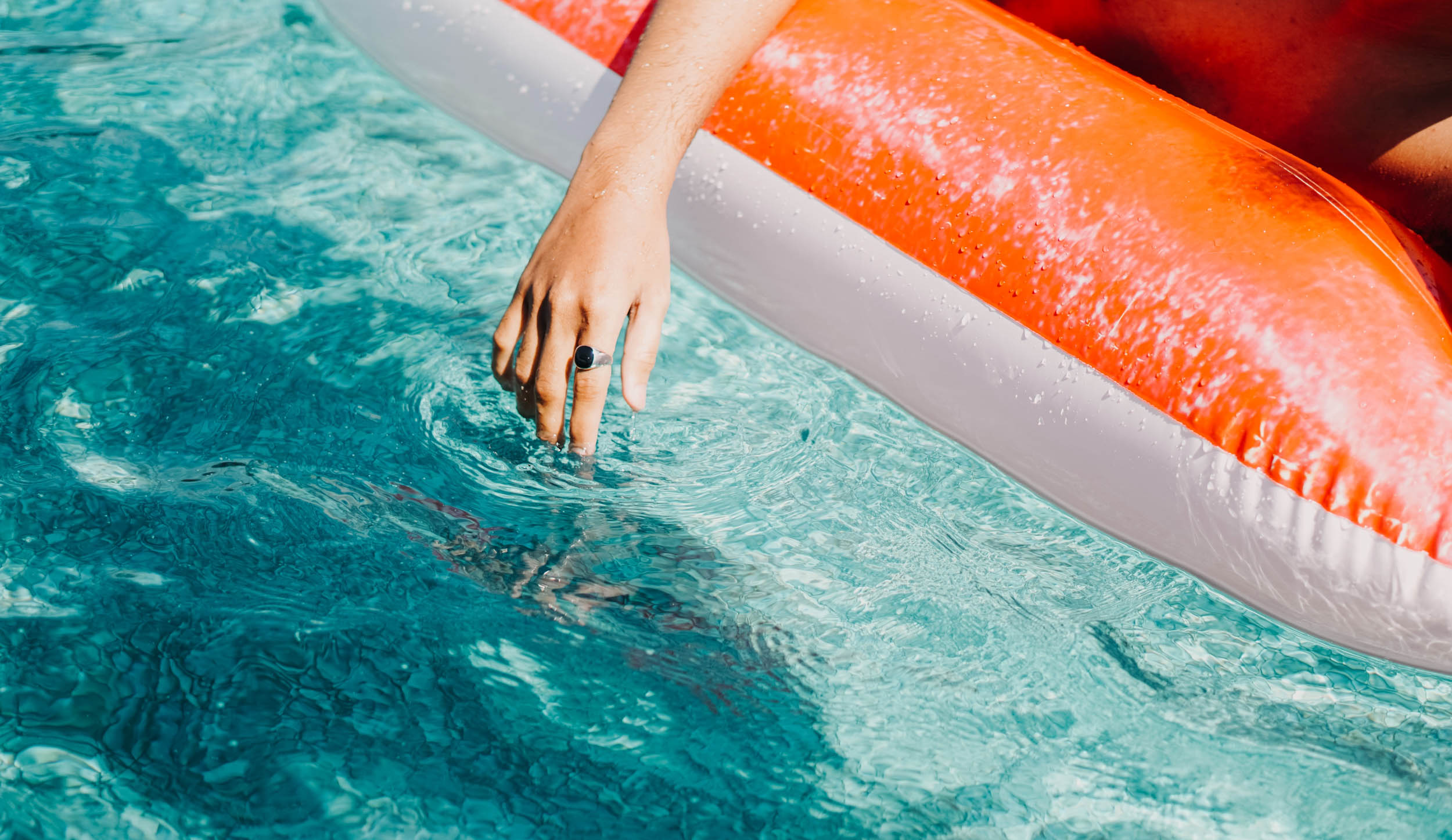 Person on pool floatie with and in the water