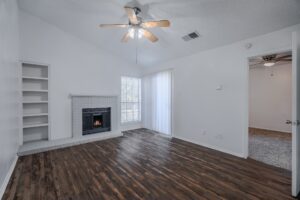 a room with a fireplace and a ceiling fan
