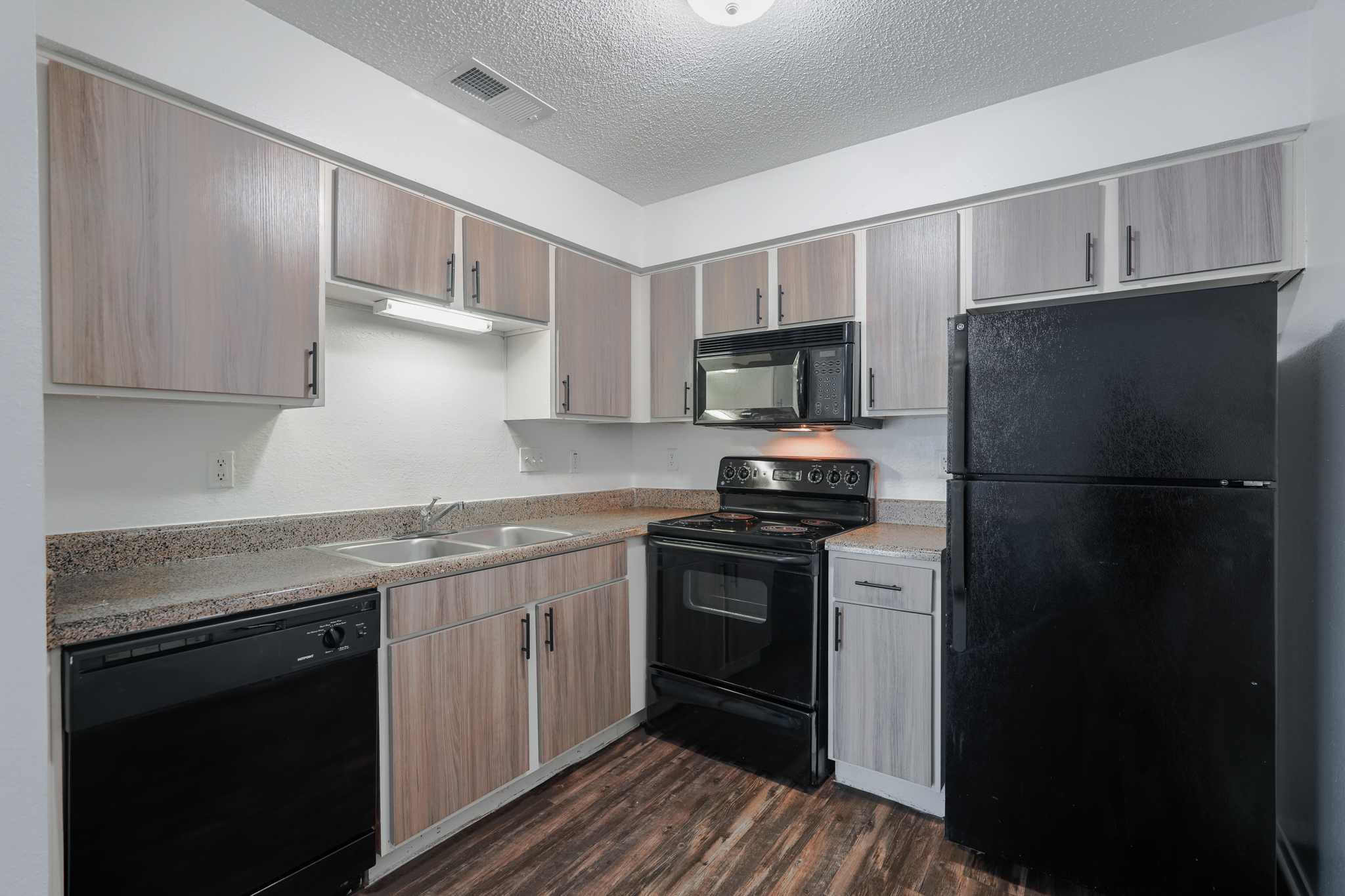 a kitchen with black appliances and a black refrigerator