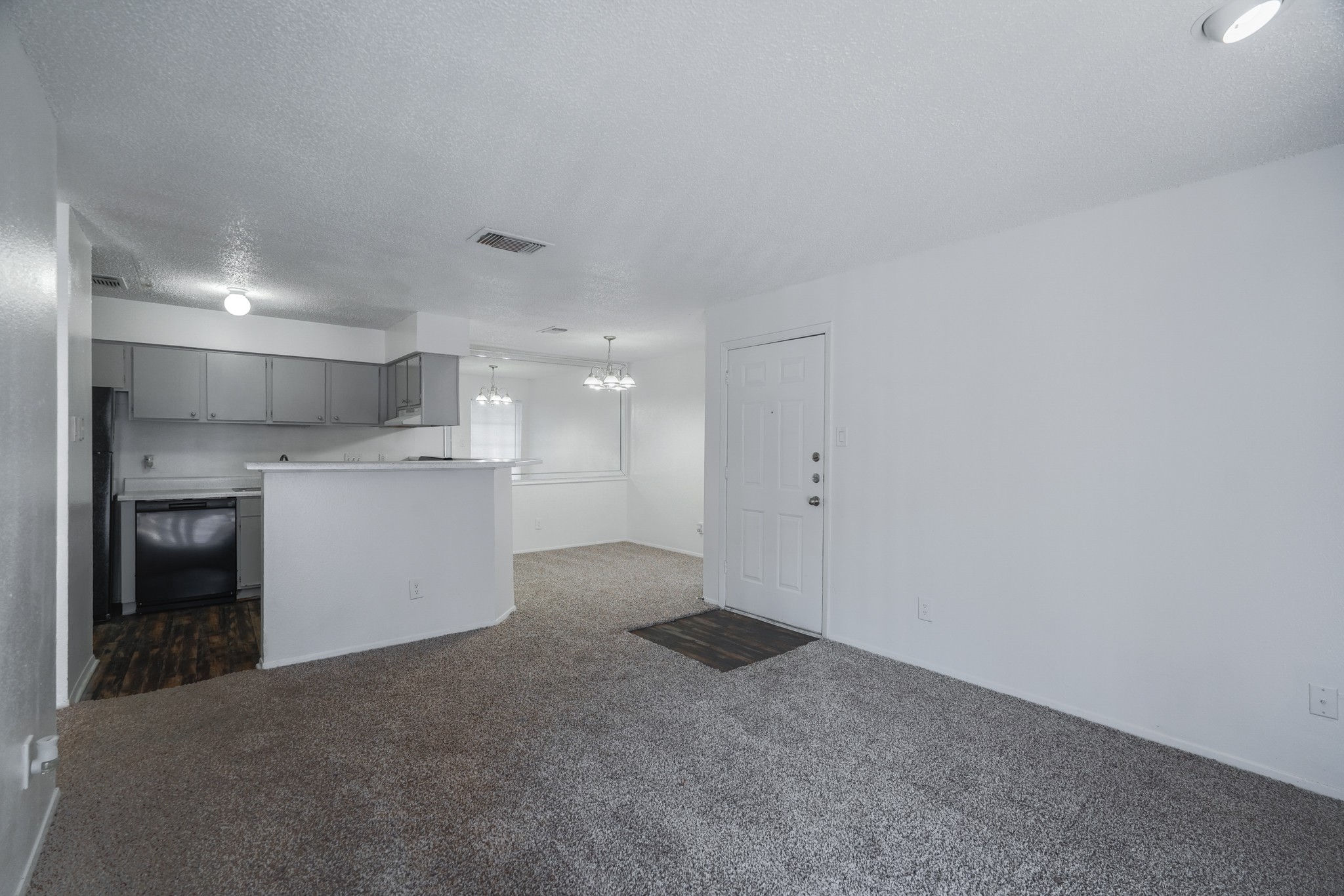 a living room with a kitchen and a door