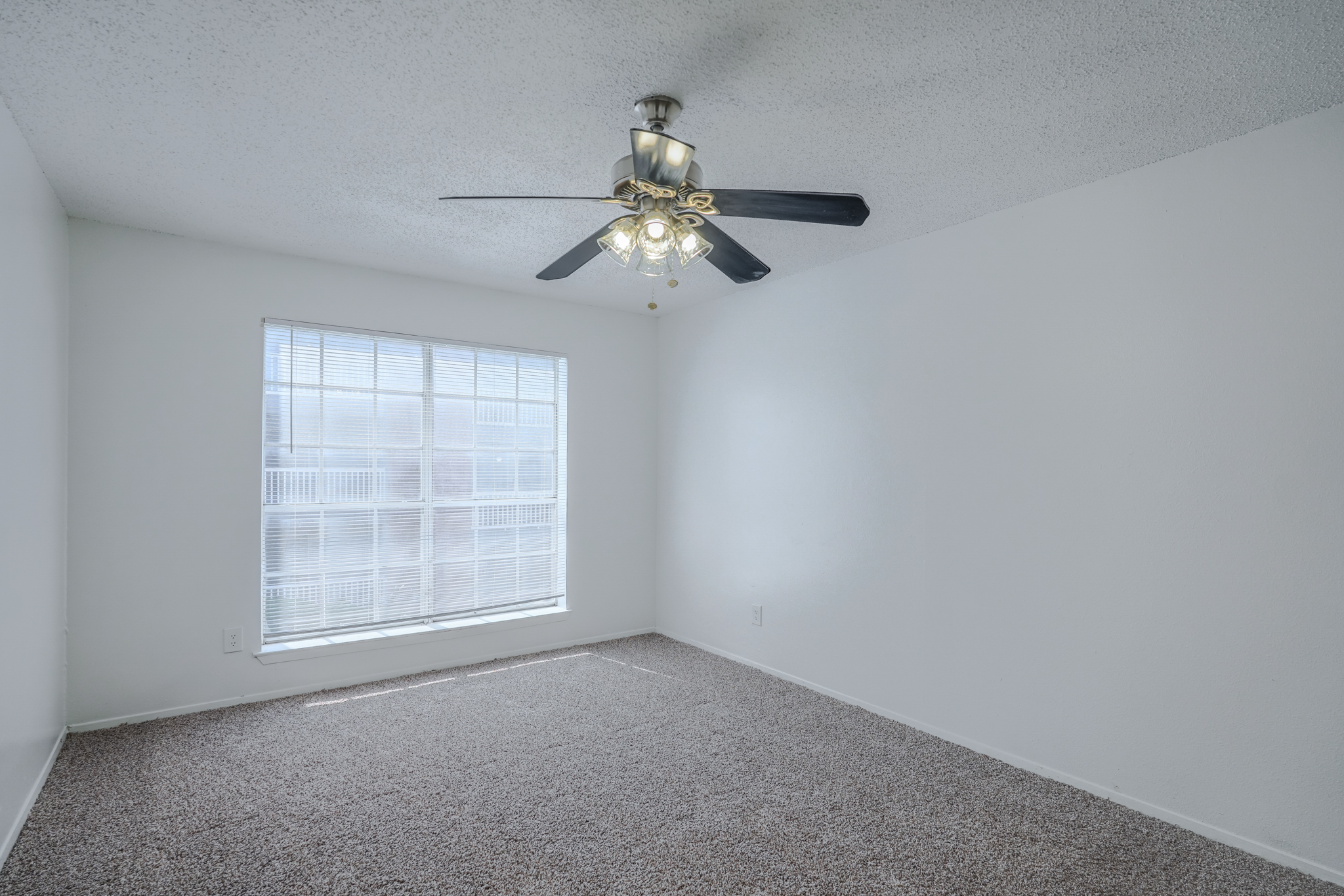 a room with a ceiling fan and a window