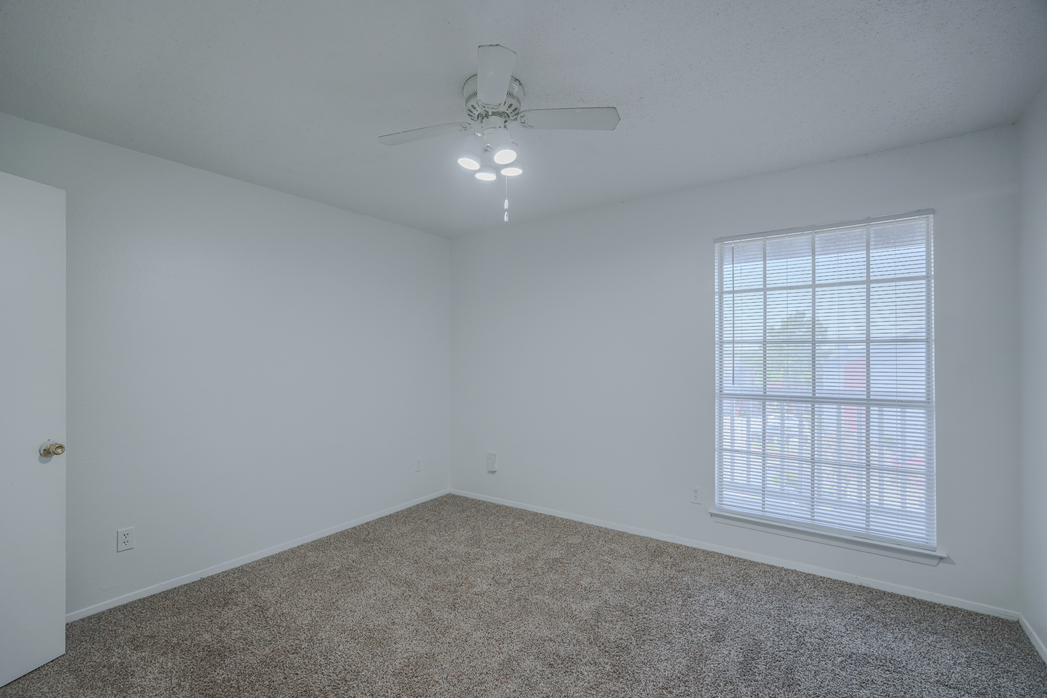 a room with a ceiling fan and a window