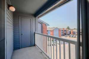 a balcony with a door and a white railing