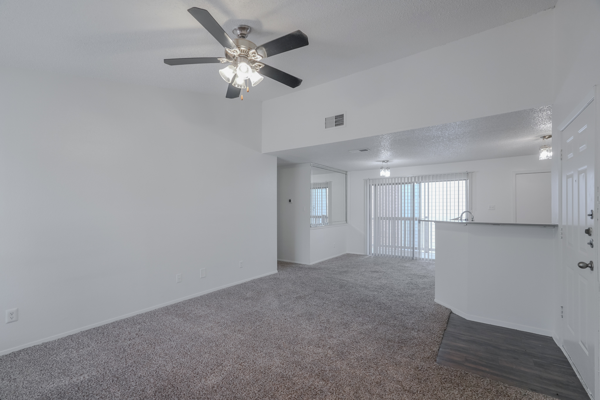 a living room with a ceiling fan and carpeted floor