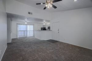 a living room with a ceiling fan and a counter