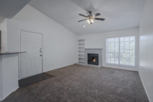 a living room with a fireplace and a ceiling fan