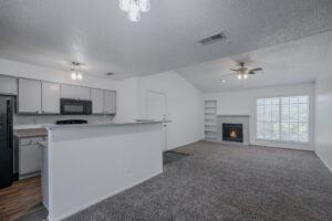 a living room with a fireplace and a kitchen