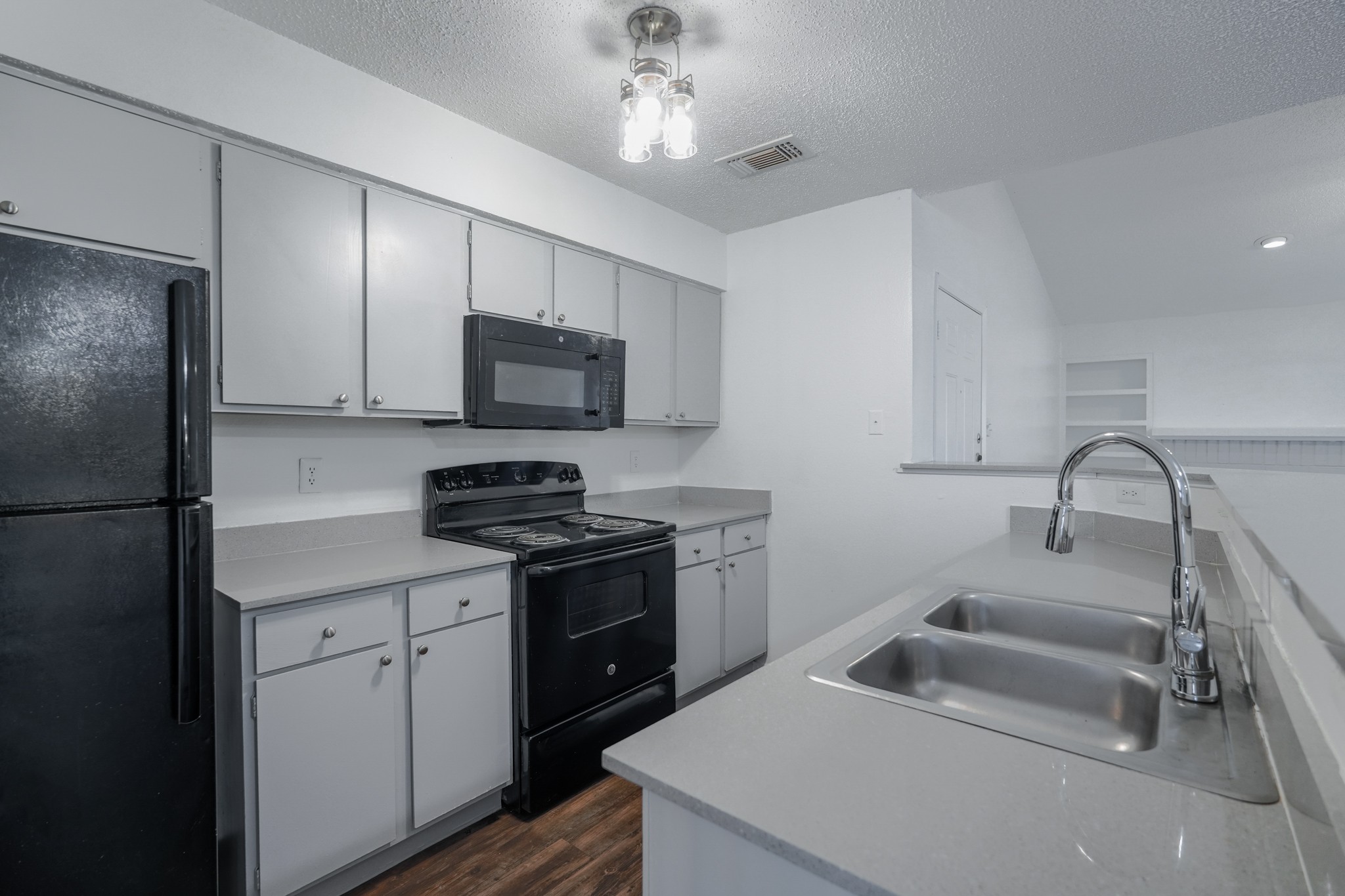 a kitchen with white cabinets and black appliances