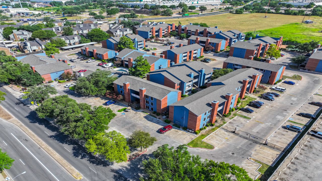 a group of buildings with cars parked in a parking lot