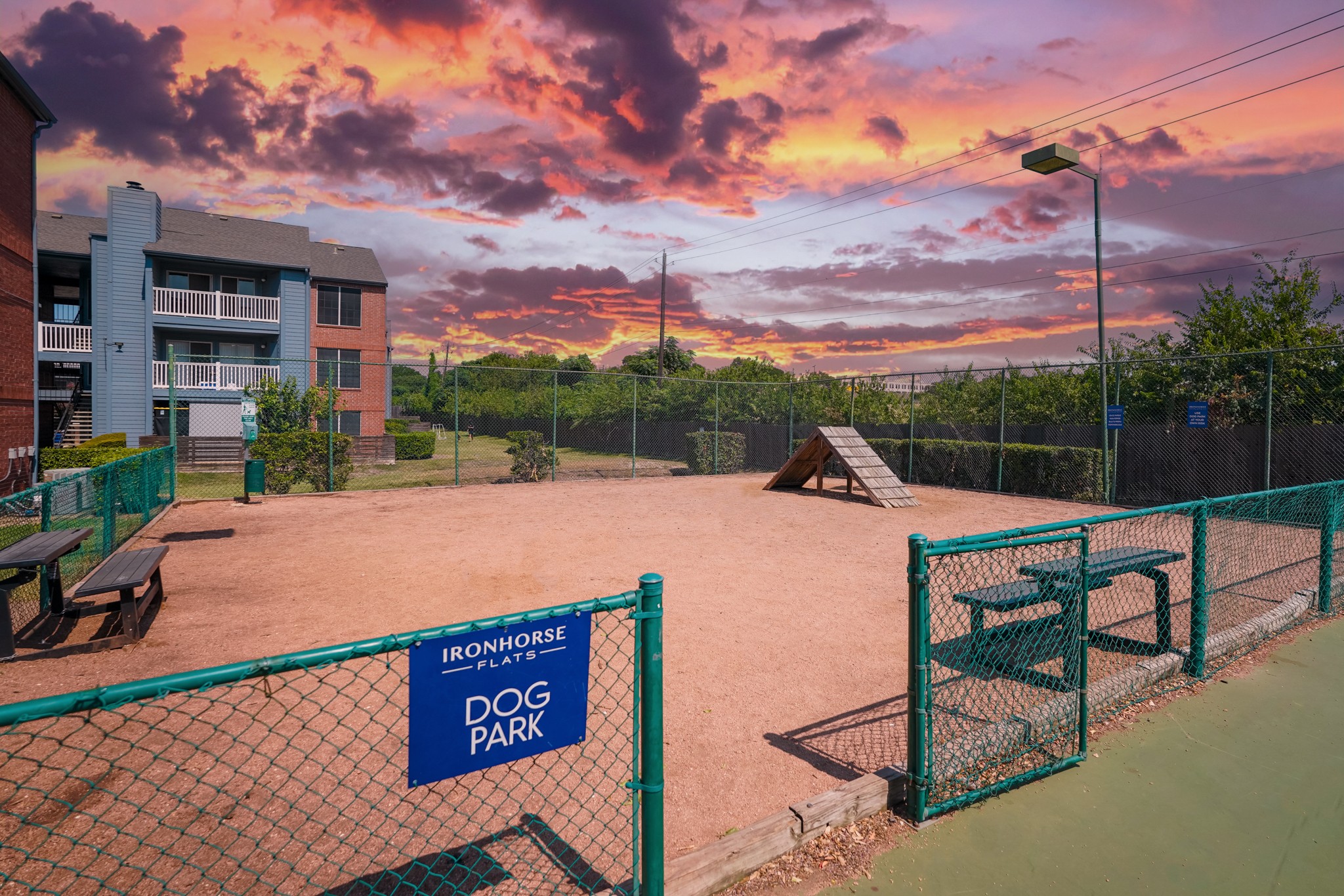 a dog park with a dog house and a fence