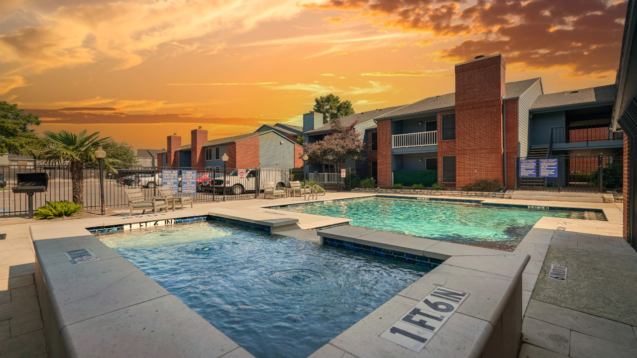 a pool with a couple of chairs and a building in the background