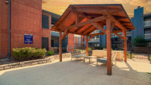 a covered patio with chairs and a building